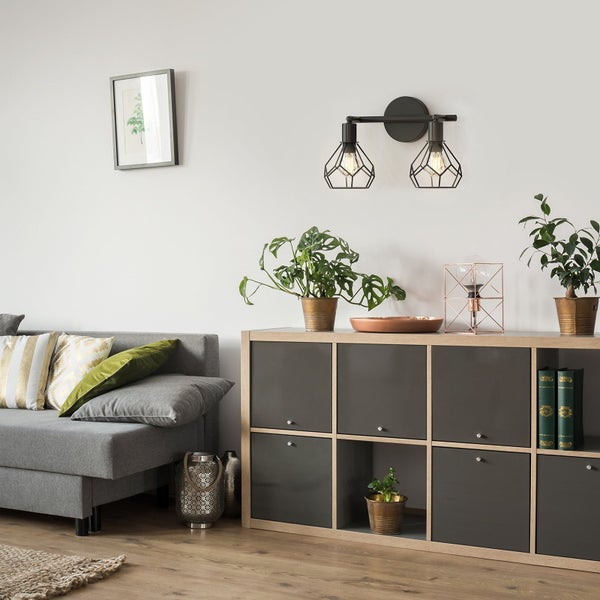 Wohnzimmer mit grauem Sofa, Regal und Wandleuchte