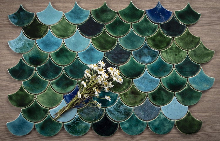 Fächerförmige Fliesen mit Blumenmuster auf einer Holzoberfläche.