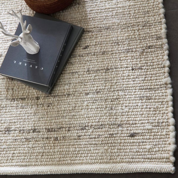 Detailansicht eines gewebten Teppichs mit Dekorationsgegenständen.