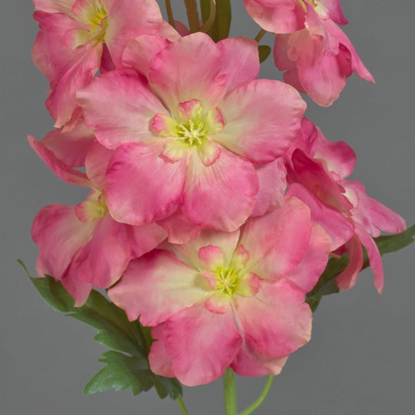 Künstliche Blume mit rosa Blüten, grünen Blättern und Stiel.