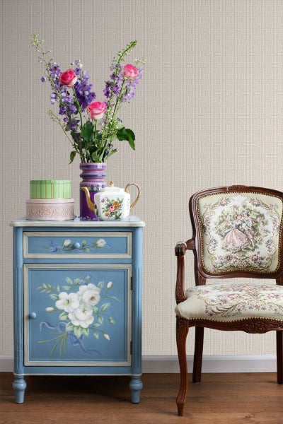 Szene mit einem blauen Nachttisch, einem Blumenstrauß, einer Teekanne und einem Stuhl mit Blumenmuster