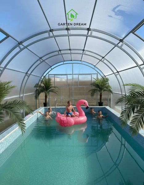 Swimmingpool mit einer transparenten Bogenüberdachung aus Metall und Polycarbonat. Kinder spielen im Wasser. Garten Dream Logo.