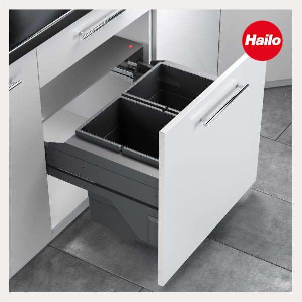 Hailo Mülltrennsystem mit zwei Abfalleimern in einer weißen Küchenschublade mit silbernem Griff auf grauem Fliesenboden.