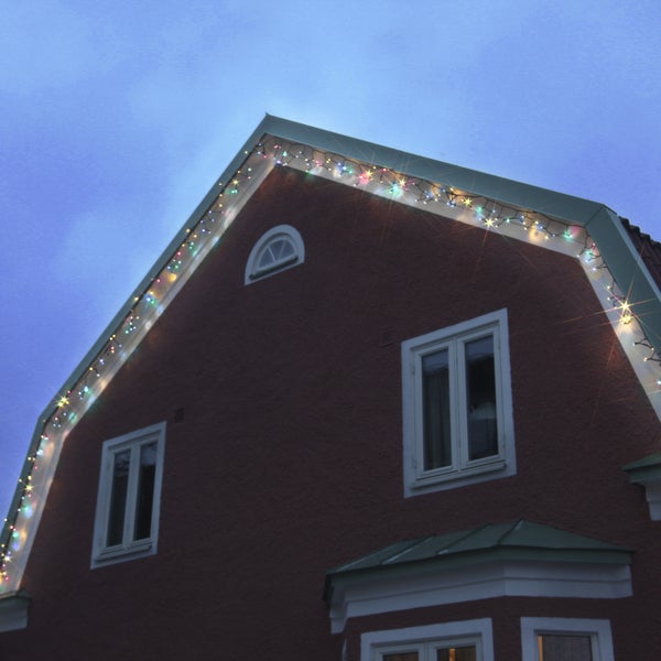 Hausfassade mit Fenster und mehrfarbiger Lichterkette