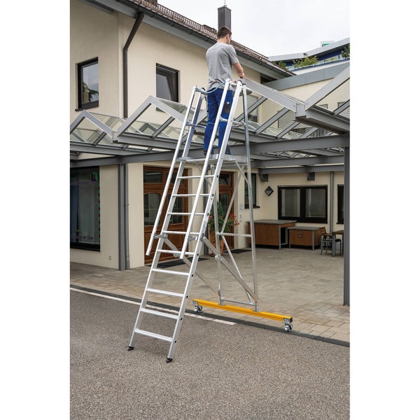 Aluminium Gerüst mit Person bei der Arbeit unter einem Glasdach.