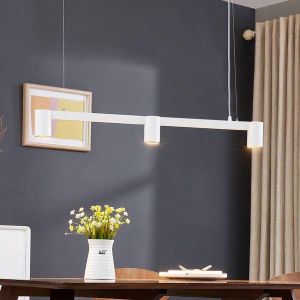 Moderne Esstischszene mit einer weißen LED-Pendelleuchte über einem Holztisch