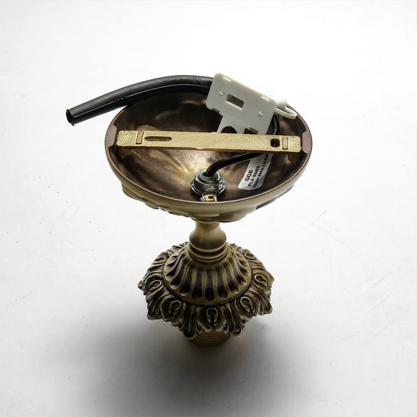 Deckenbefestigung für eine Lampe mit dekorativen Elementen.