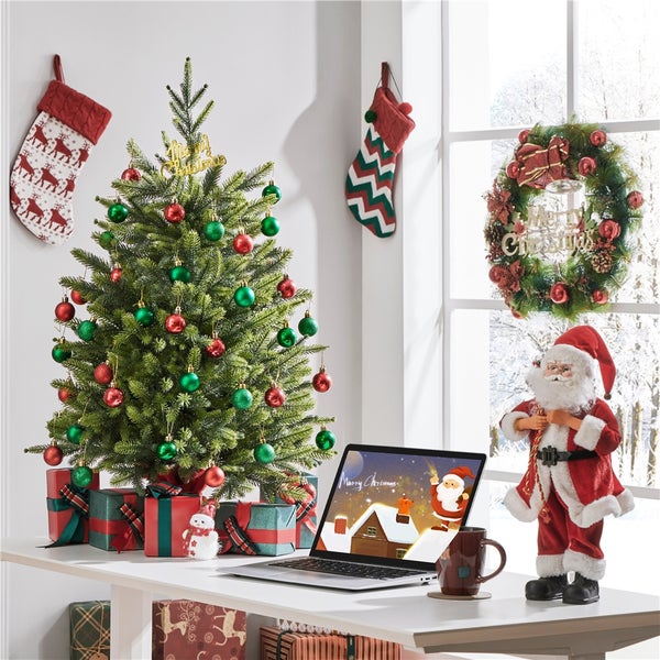 Festlich dekorierter Raum mit Weihnachtsbaum, Geschenken, Laptop und Weihnachtsmannfigur