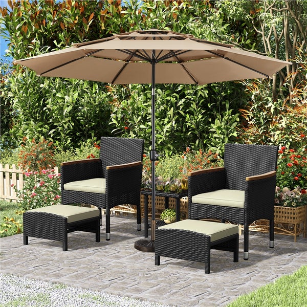 Gartenmöbelset mit zwei Sesseln, zwei Hockern und einem Sonnenschirm auf einer Terrasse