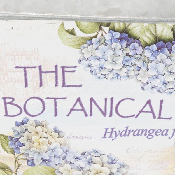 Detailansicht eines Pflanzgefäßes mit Hortensien-Motiv und dem Text THE BOTANICAL.