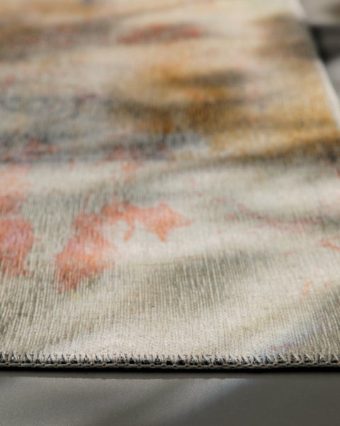 Detailaufnahme eines Teppichs mit abstraktem Muster und geketteltem Rand.