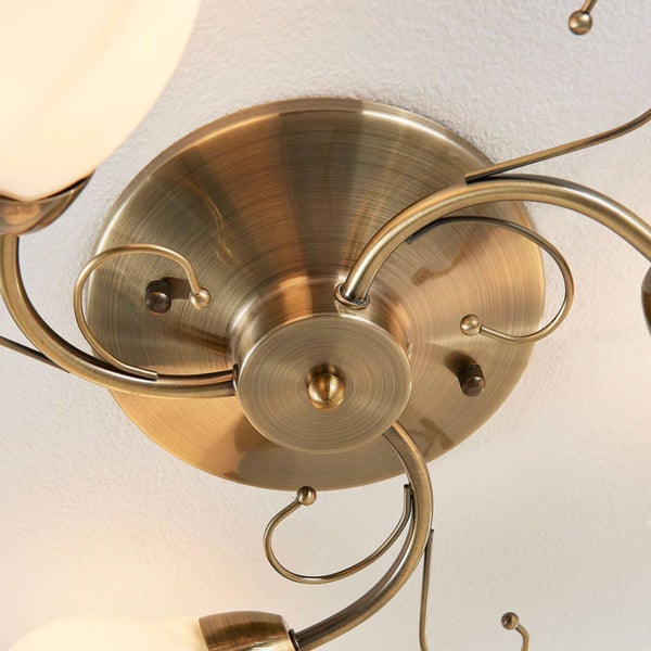 Detailansicht einer Deckenleuchte im Vintage-Stil mit Messingelementen und Glaskugeln.