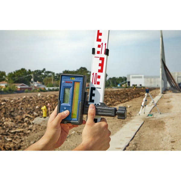 Bosch Logo. Eine Person hält ein digitales Nivelliergerät an einer Messlatte.