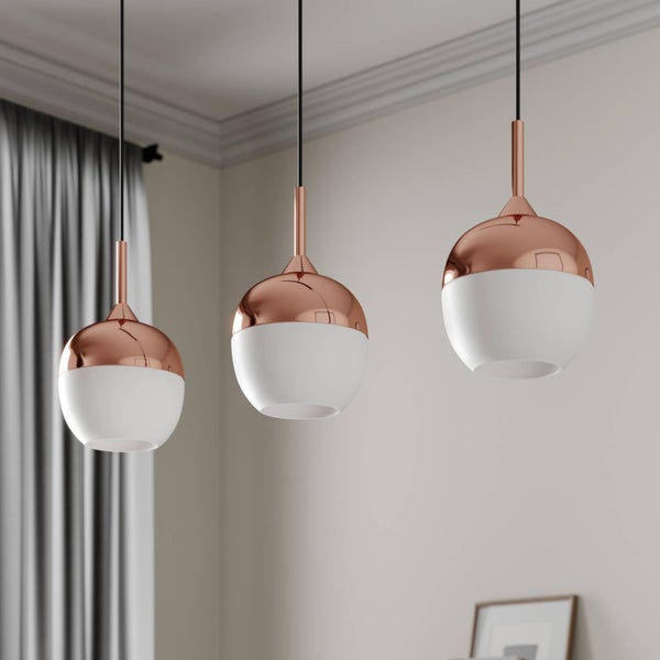 Drei moderne Pendelleuchten mit kugelförmigen Schirmen aus Kupfer und weißem Glas in einem hellen Raum.