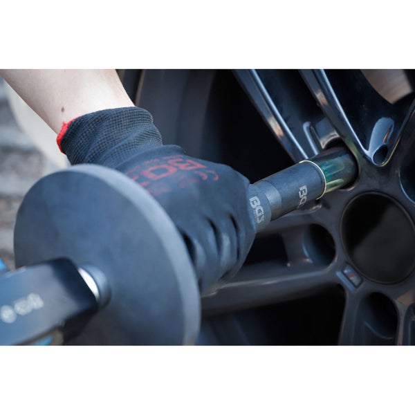 Eine Person benutzt einen Drehmomentschlüssel mit einer Stecknuss an einem Autorad