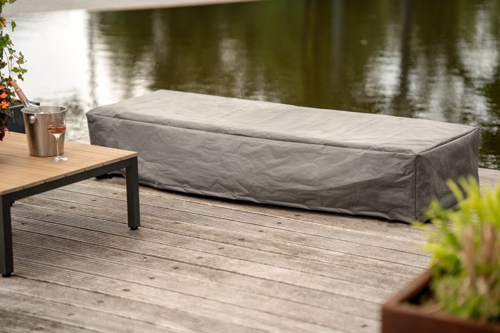 Graue Schutzhülle für Gartenmöbel auf einer Holzterrasse