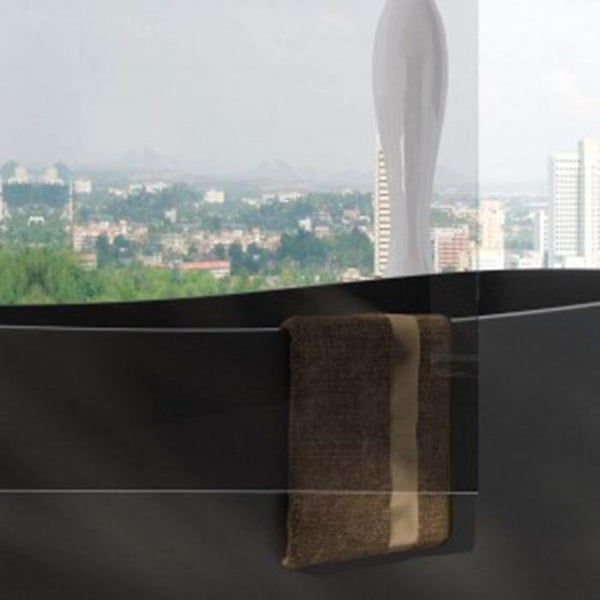 Ein braunes Handtuch hängt über einer transparenten Glaswand mit Blick auf eine städtische Umgebung.