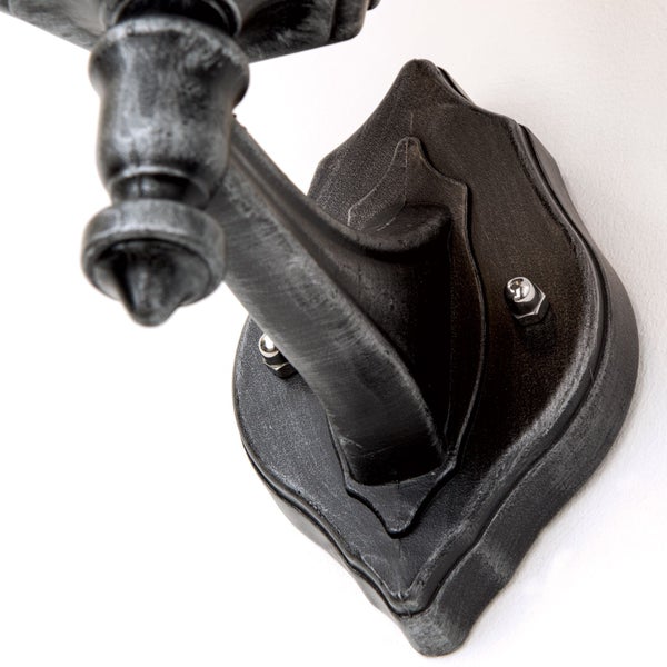 Wandhalterung einer Außenleuchte aus Metall im antiken Stil mit dekorativer Wandplatte.