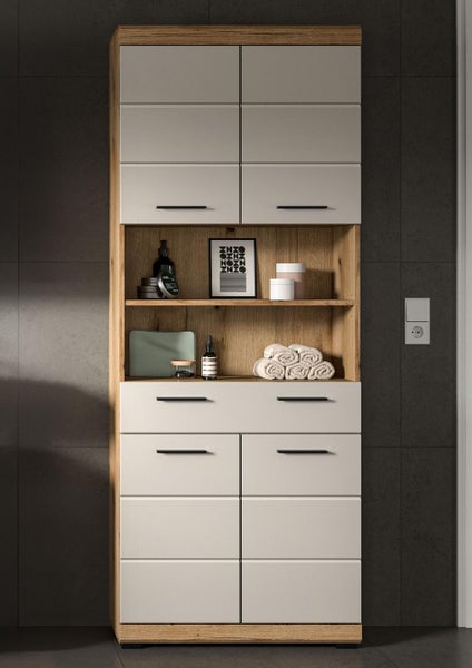 Hoher Badezimmerschrank in Eichenoptik mit hellgrauen Fronten, Türen, zwei Schubladen und offenen Regalfächern.