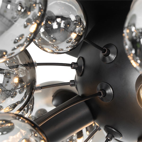 Detailaufnahme einer Leuchte mit Glaskugeln und schwarzem Gestell