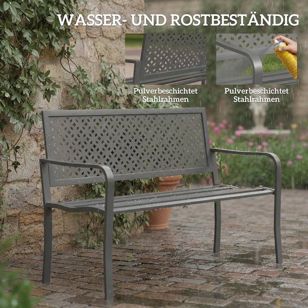 Graue Zweisitzerbank aus Metall auf einer Terrasse mit einem Paar, das den Sonnenuntergang betrachtet.