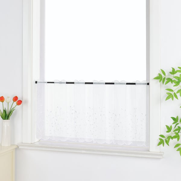 Gardinenstore mit floralem Muster am Fenster