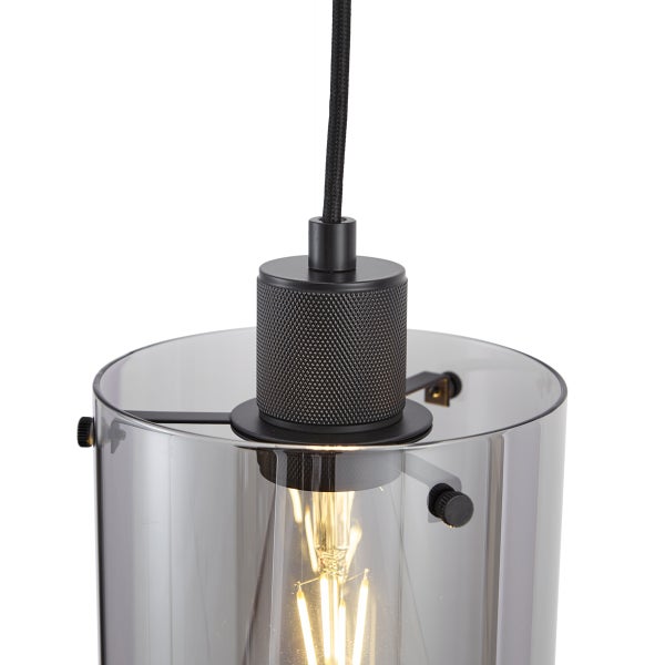 Pendelleuchte mit transparentem, zylinderförmigem Lampenschirm.