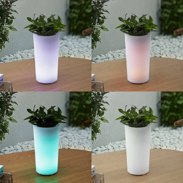 Vier Ansichten eines zylindrischen Pflanztopfs mit einer grünen Pflanze, der in verschiedenen Farben auf einem Holztisch im Außenbereich leuchtet.