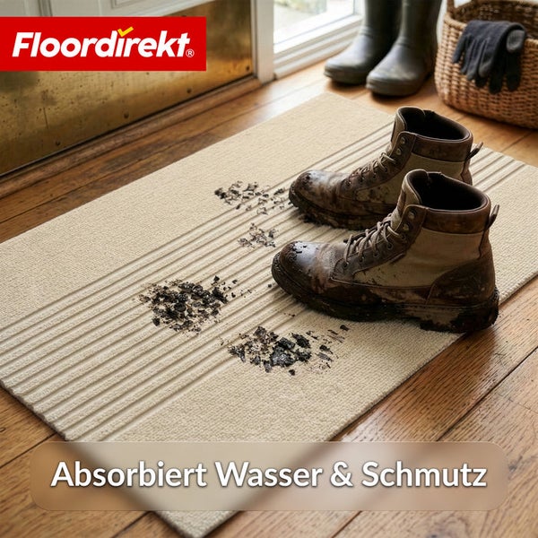 Beige strukturierte Fußmatte mit schlammigen Arbeitsschuhen auf Holzfußboden. Floordirekt Logo. Absorbiert Wasser und Schmutz.