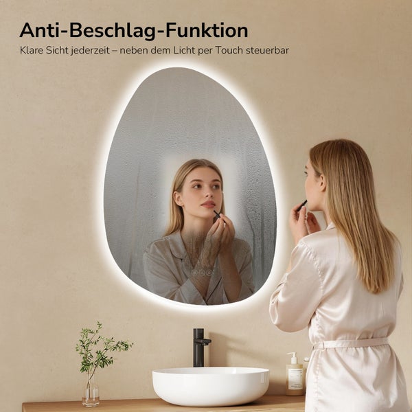 Asymmetrischer LED-Badspiegel mit Anti-Beschlag-Funktion, Badezimmerszene mit Aufsatzwaschbecken, schwarzer Armatur und Frau im Spiegelbild.