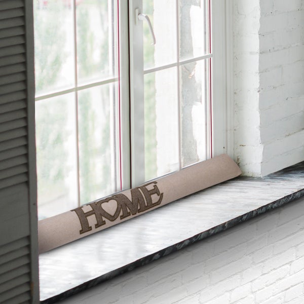 Zugluftstopper mit der Aufschrift Home auf einer Fensterbank