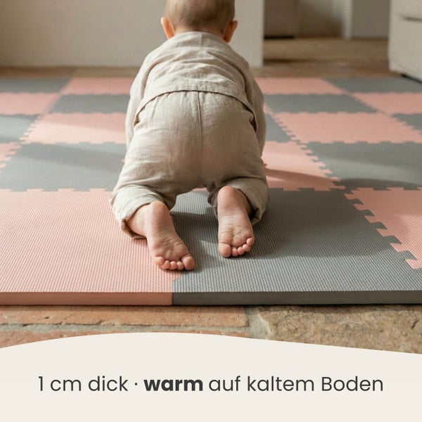 Kleinkind krabbelt auf einer 1 Zentimeter dicken, wärmeisolierenden Puzzlematte aus Schaumstoff auf einem Steinboden.