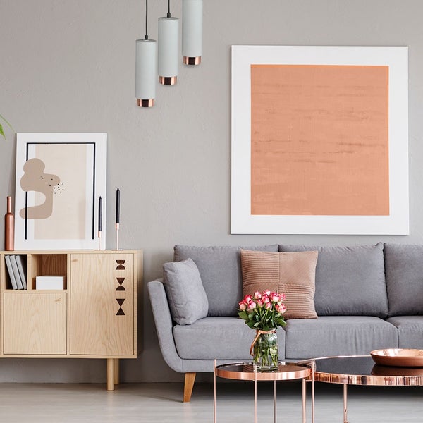 Wohnzimmer mit Sofa, Schrank, Pendelleuchten und Dekorationen für eine stilvolle Inneneinrichtung
