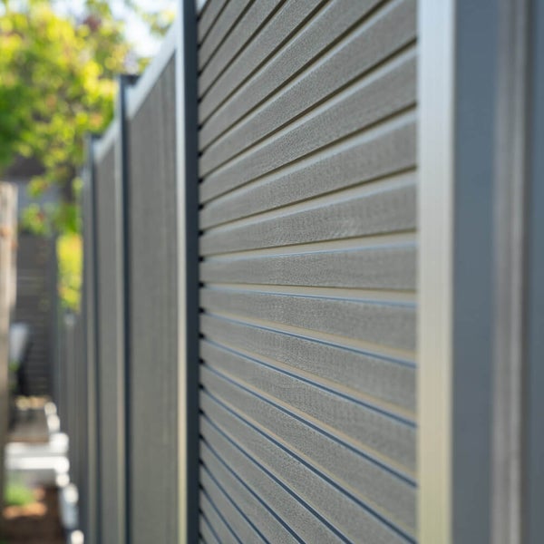 Moderner Sichtschutzzaun aus Kunststoff Lamellen mit stabilen Metallpfosten als Gestaltungselement im Garten