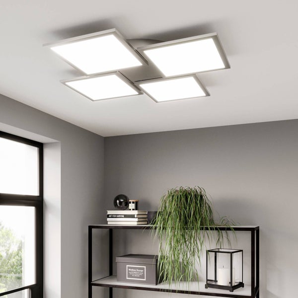 Moderne LED-Deckenleuchte mit vier quadratischen Paneelen in einem grau gestalteten Wohnraum mit einem schwarzen Metallregal.