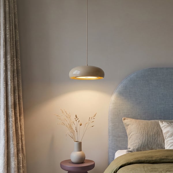Moderne Pendelleuchte über einem Nachttisch mit Bett im Schlafzimmer