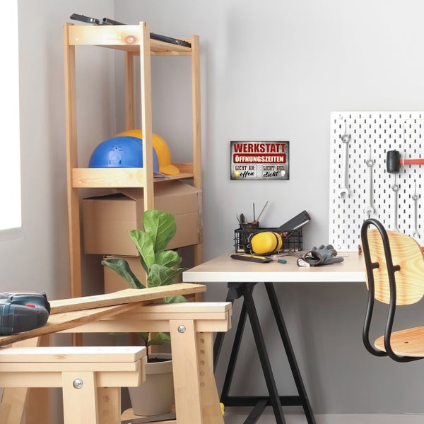 Eingerichtete Werkstatt mit Werkbank, Werkzeugwand, Holzregal und Metallschild Werkstatt Öffnungszeiten an der Wand.