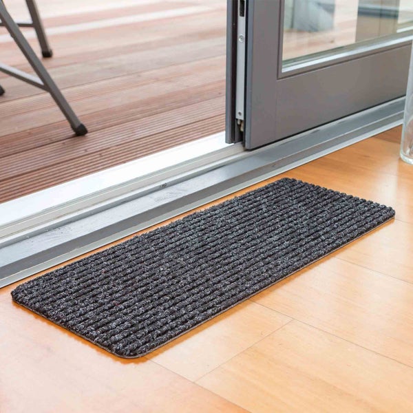 Schmutzfangmatte vor einer Terrassentür auf Holzboden
