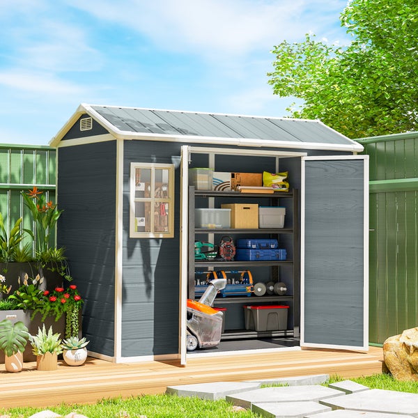 Graues Gerätehaus mit offenen Doppeltüren und Innenregalen für Werkzeuge, auf einer Holzterrasse im Garten platziert.