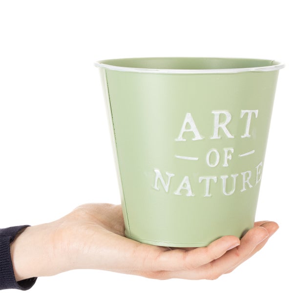 Metall-Blumentopf in einer Hand gehalten mit der Prägung Art of Nature.
