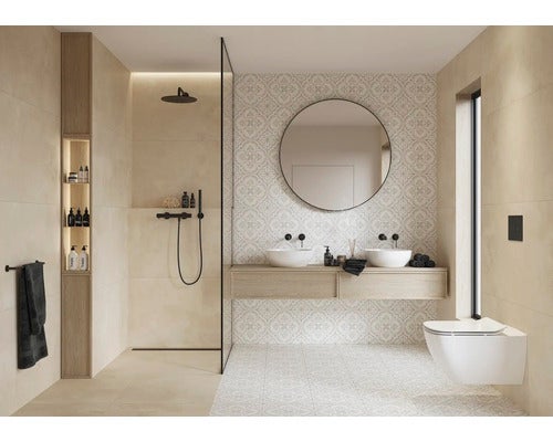 Bad mit begehbarer Dusche, Doppelwaschtisch, Rundspiegel und Wandtoilette. Gemusterte Fliesen und großformatige Wand- und Bodenfliesen aus Naturstein.