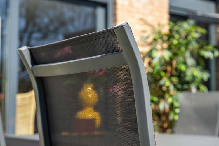 Rückenlehne eines Gartenstuhls aus Aluminium mit Textilgewebe im Freien.