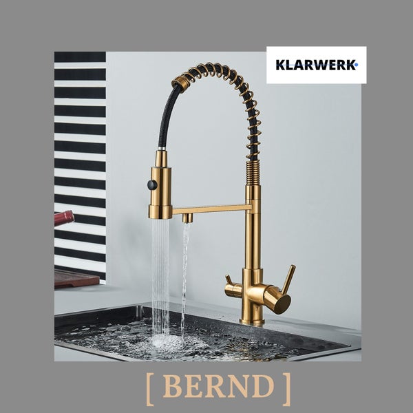 Klarwerk Bernd Küchenarmatur mit Spiralfeder-Brause und zusätzlichem Auslauf, Messingoptik, montiert an einer Spüle mit fließendem Wasser. Klarwerk Logo.
