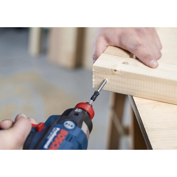 Eine Person schraubt eine Schraube mit einem Akkuschrauber in ein Holzbrett