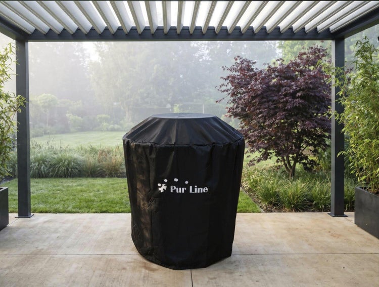 Pur Line Abdeckhaube für Gartenmöbel oder Grill auf einer Terrasse unter einer Pergola mit Blick in einen weitläufigen Garten.