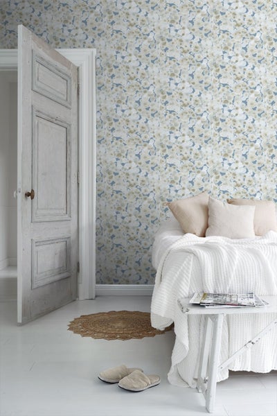 Tapete mit abstraktem Muster aus überlappenden runden Punkten in Beige und Weiß auf blau-grauem Hintergrund.