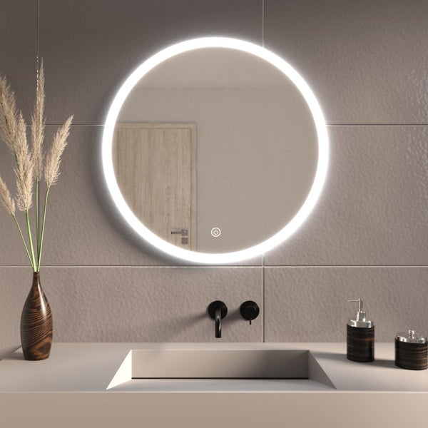 Runder LED Badezimmerspiegel mit integrierter Touch Bedienung montiert an einer gefliesten Wand über einem modernen Waschbecken mit Armatur.