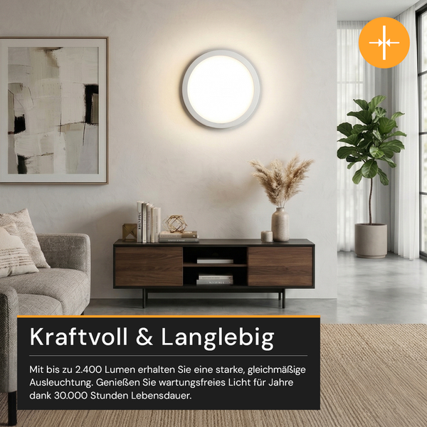 Moderne, helle Wohnzimmergestaltung mit runder LED-Wandleuchte, Sideboard aus Holz, Sofa und einer großen Zimmerpflanze.