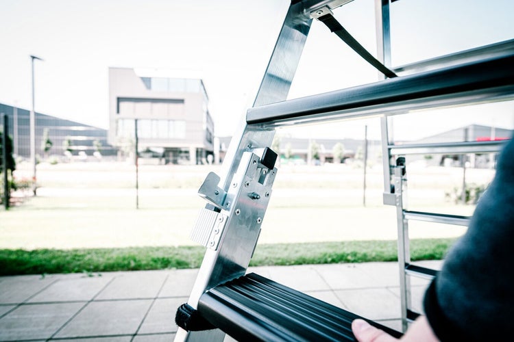 Detailansicht einer Aluminiumleiter mit schwarzer Stufe und Arretierungsmechanismus