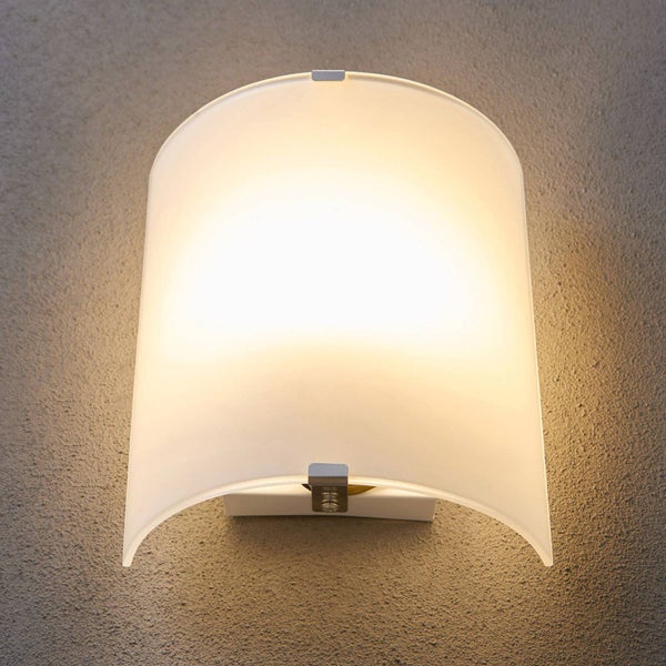 Beleuchtete Wandleuchte mit gewölbtem Schirm aus mattem Glas an einer strukturierten Wand.